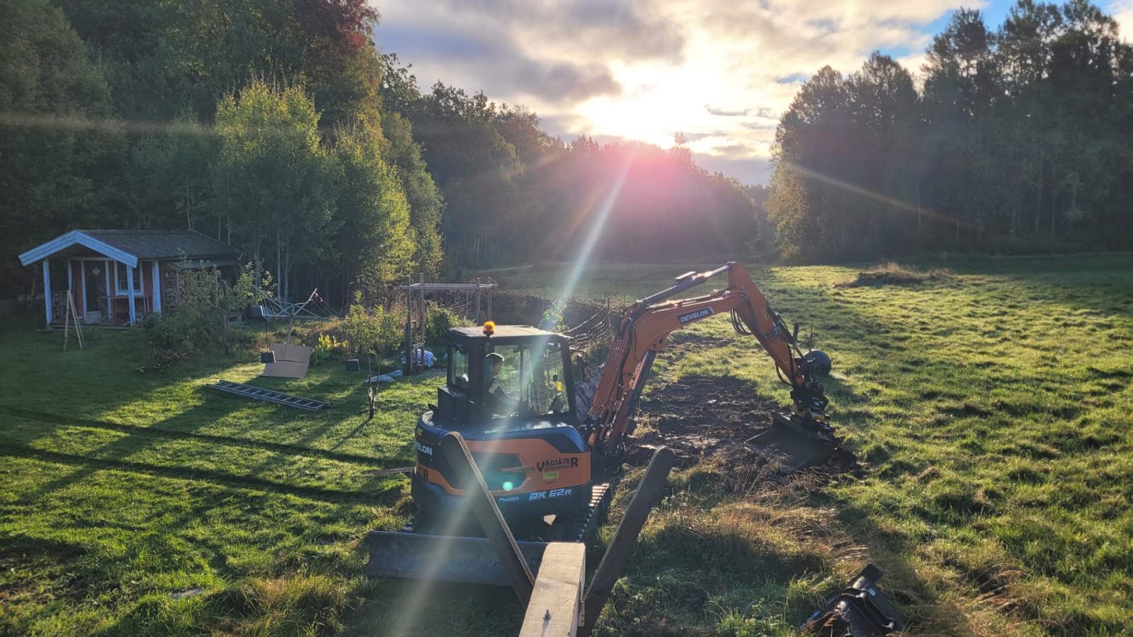 Grävmaskin i arbete i morgonsol